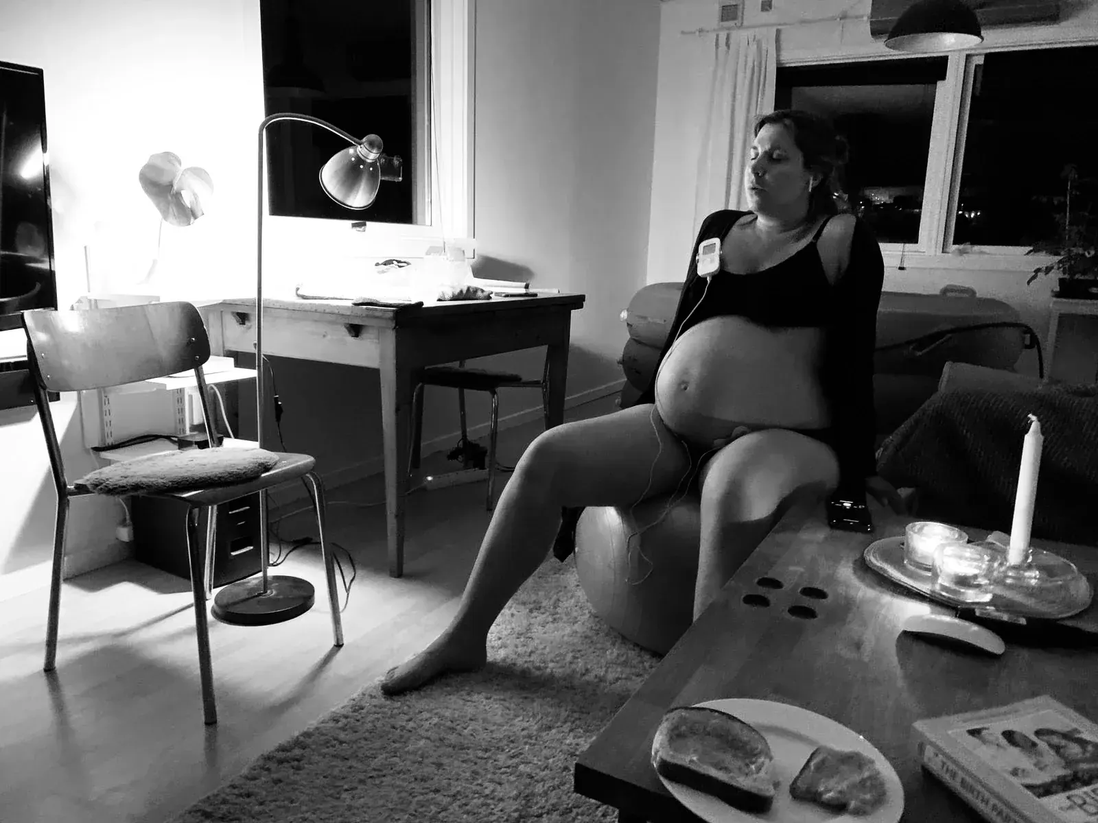 Aniara sitter på pilatesbollen i matrummet i nattens dunkla ljus och andas genom en värk.