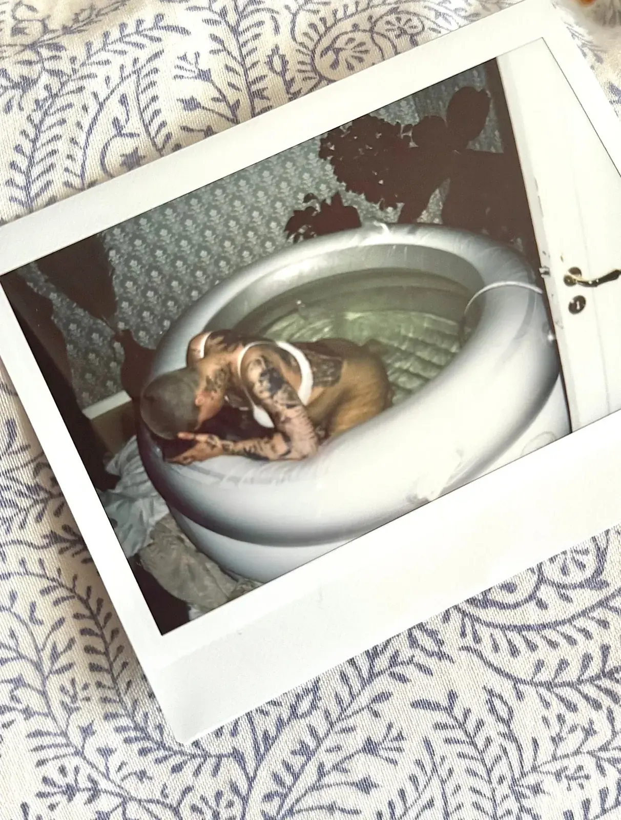 Polaroidbild av Hanna lutad framåt i förlossningspoolen hemma.